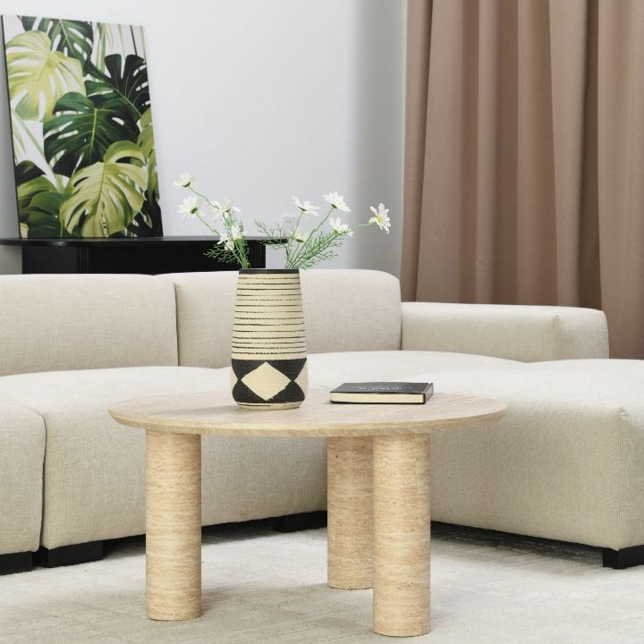 Close-up lifestyle shot of the Nils coffee table surface styled with a black decorative book and a geometric vase