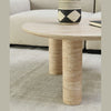 High-angle lifestyle view showcasing the Nils table in natural light to highlight the organic depth of the travertine