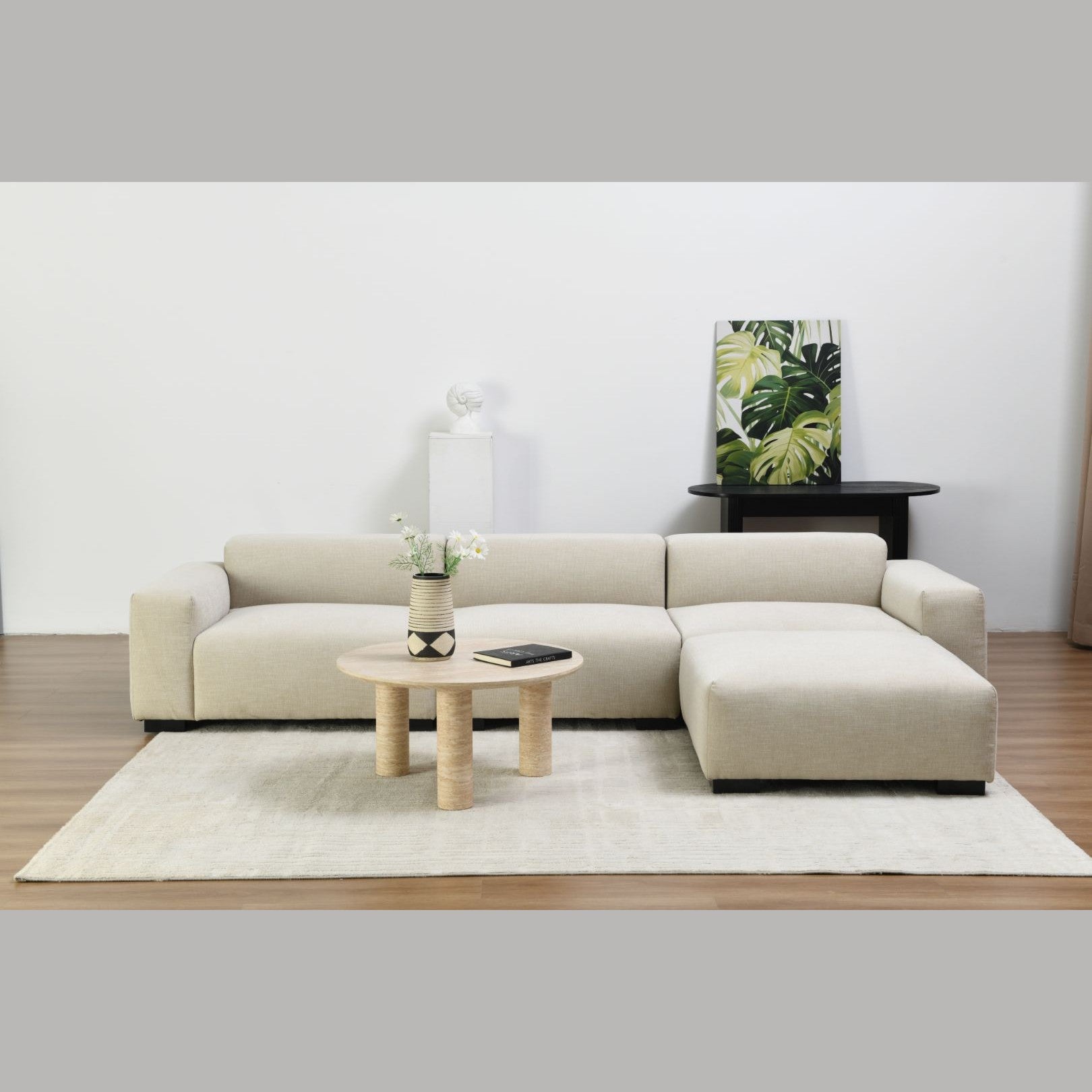 Lifestyle shot featuring the Nils coffee table styled with a white modular sectional sofa in a bright contemporary living room
