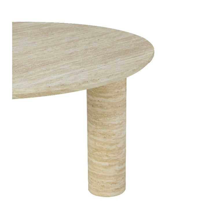 Close-up shot focusing on the smooth rounded edge of the circular travertine tabletop and the top of a pedestal leg