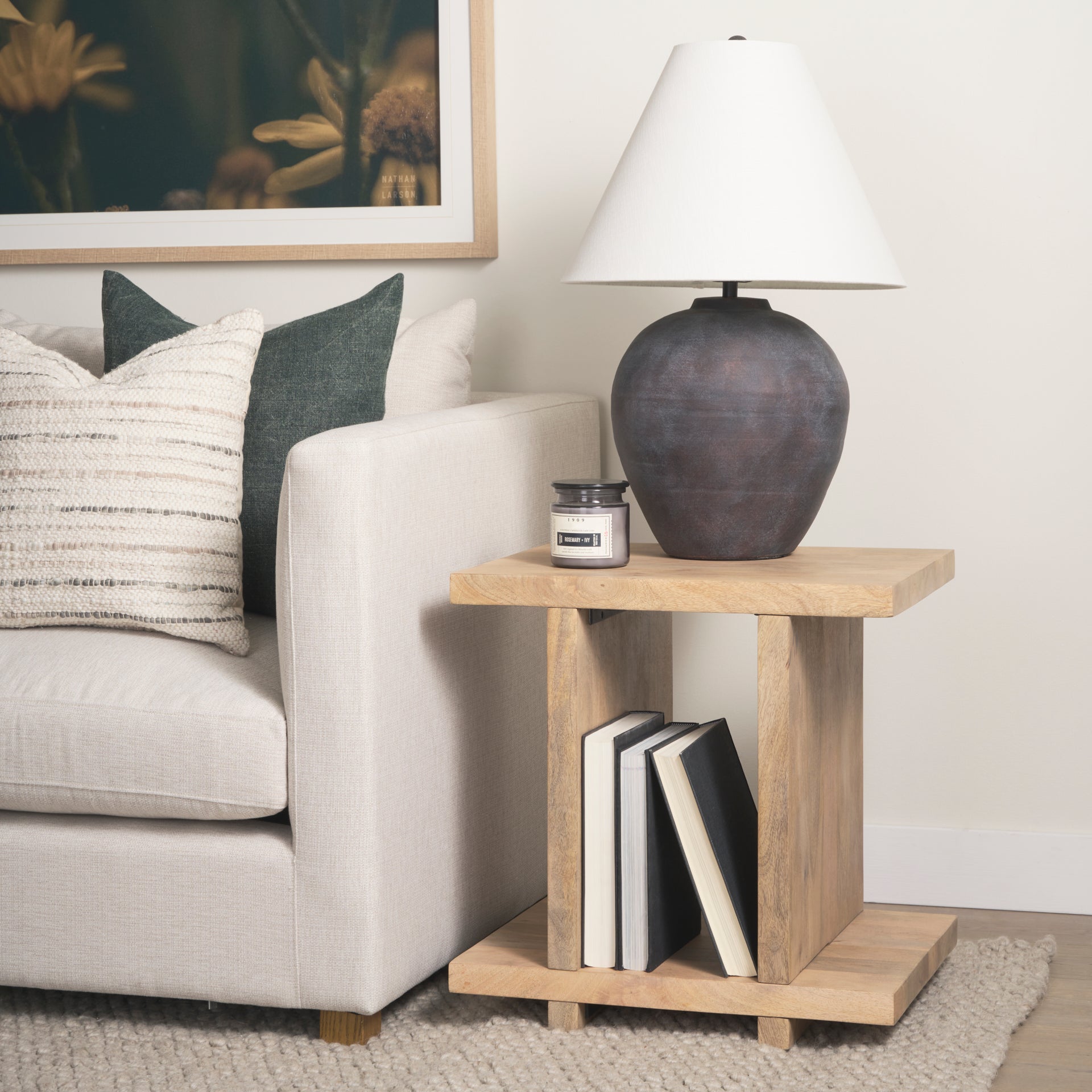 Straight-on front view highlighting the architectural H-frame silhouette and symmetrical design of the light brown wood table