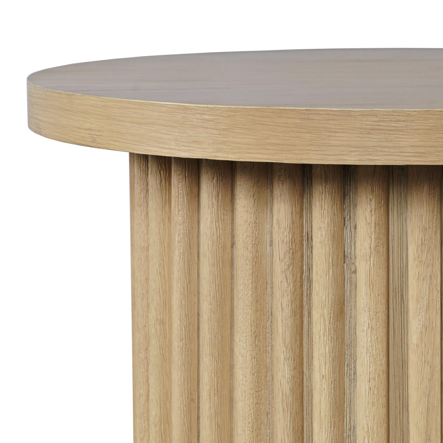 Perspective shot highlighting the vertical wood slats of the fluted base and the slight overhang of the smooth natural oak tabletop