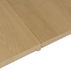 Close-up high-angle shot focusing on the smooth wood surface and the precision center joint of the natural oak tabletop