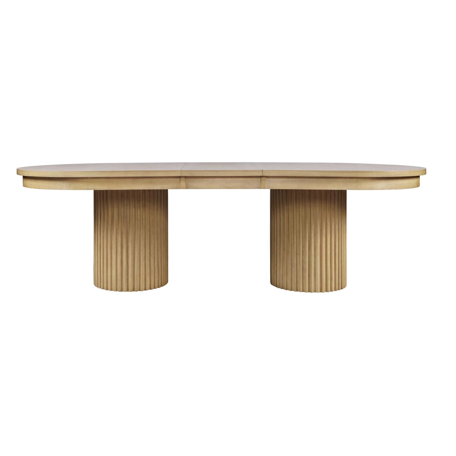 Front view of the Nord dining table in a natural oak finish featuring an oval tabletop and two thick fluted pedestal bases