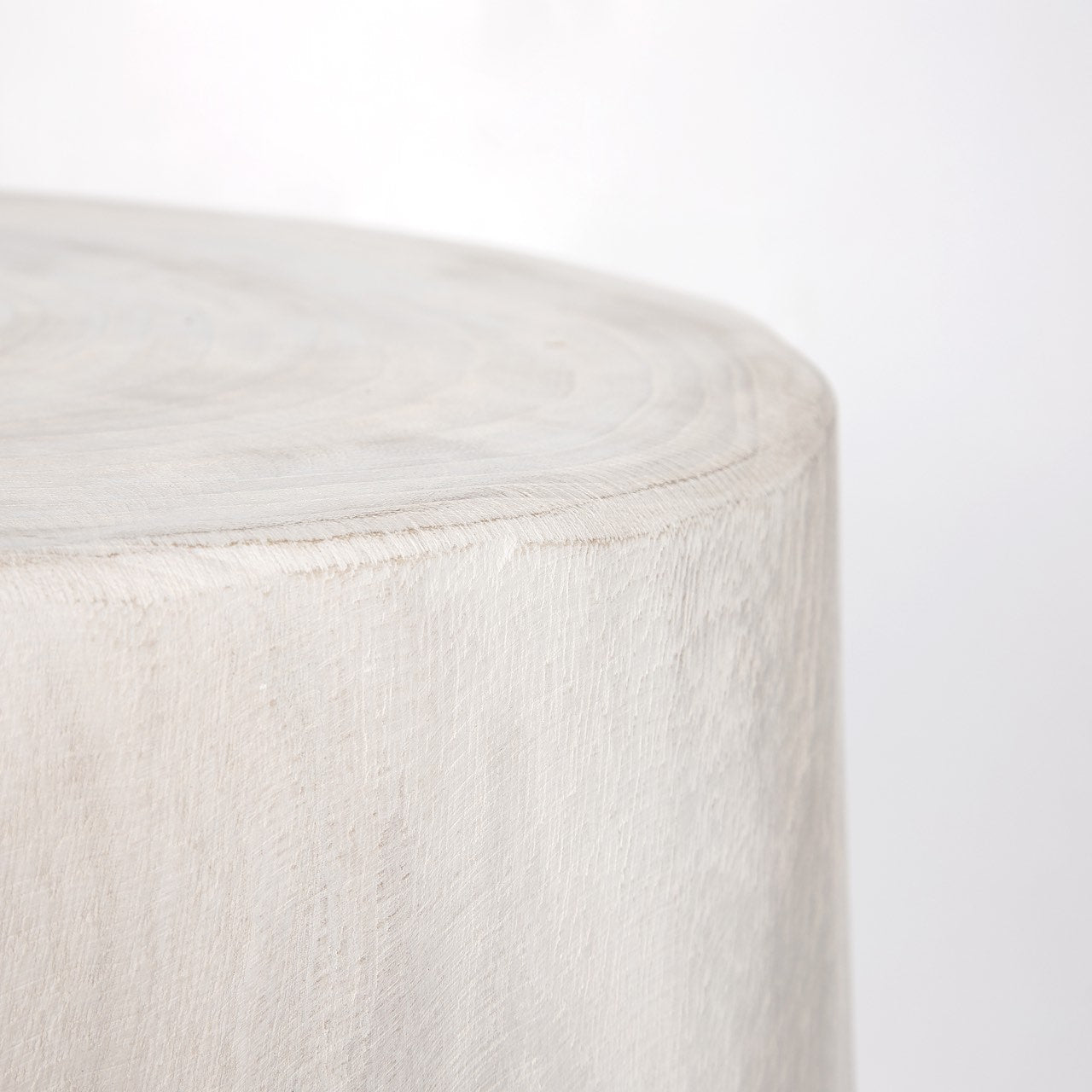 Macro shot focusing on the rustic white-washed finish and the soft vertical wood grain along the table edge