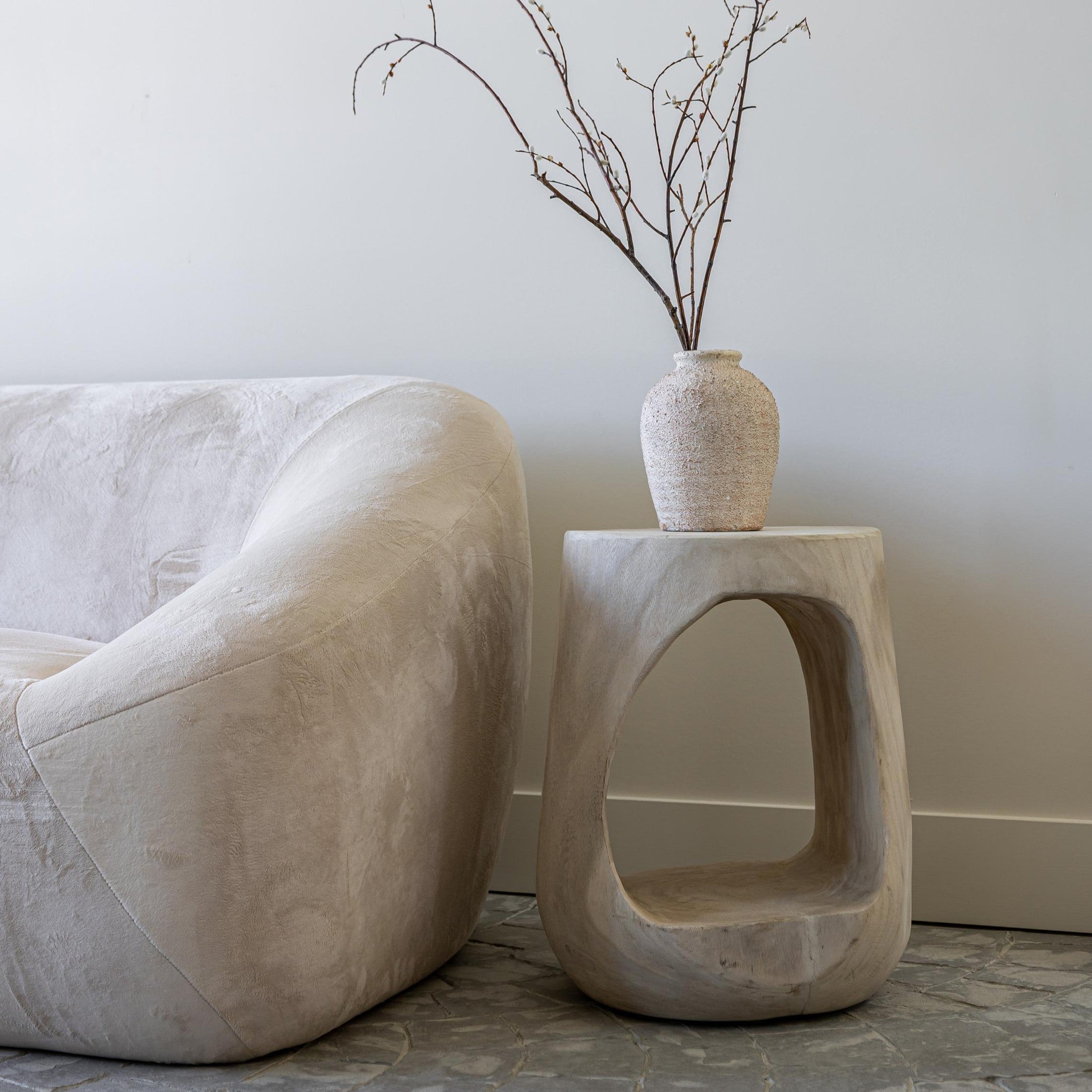Lifestyle shot featuring the Nova Drift table styled with a ceramic vase in an airy minimalist interior setting