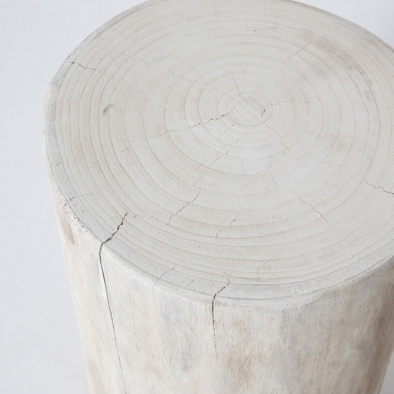 Close-up high-angle view highlighting the natural tree ring patterns and authentic wood cracks on the circular top