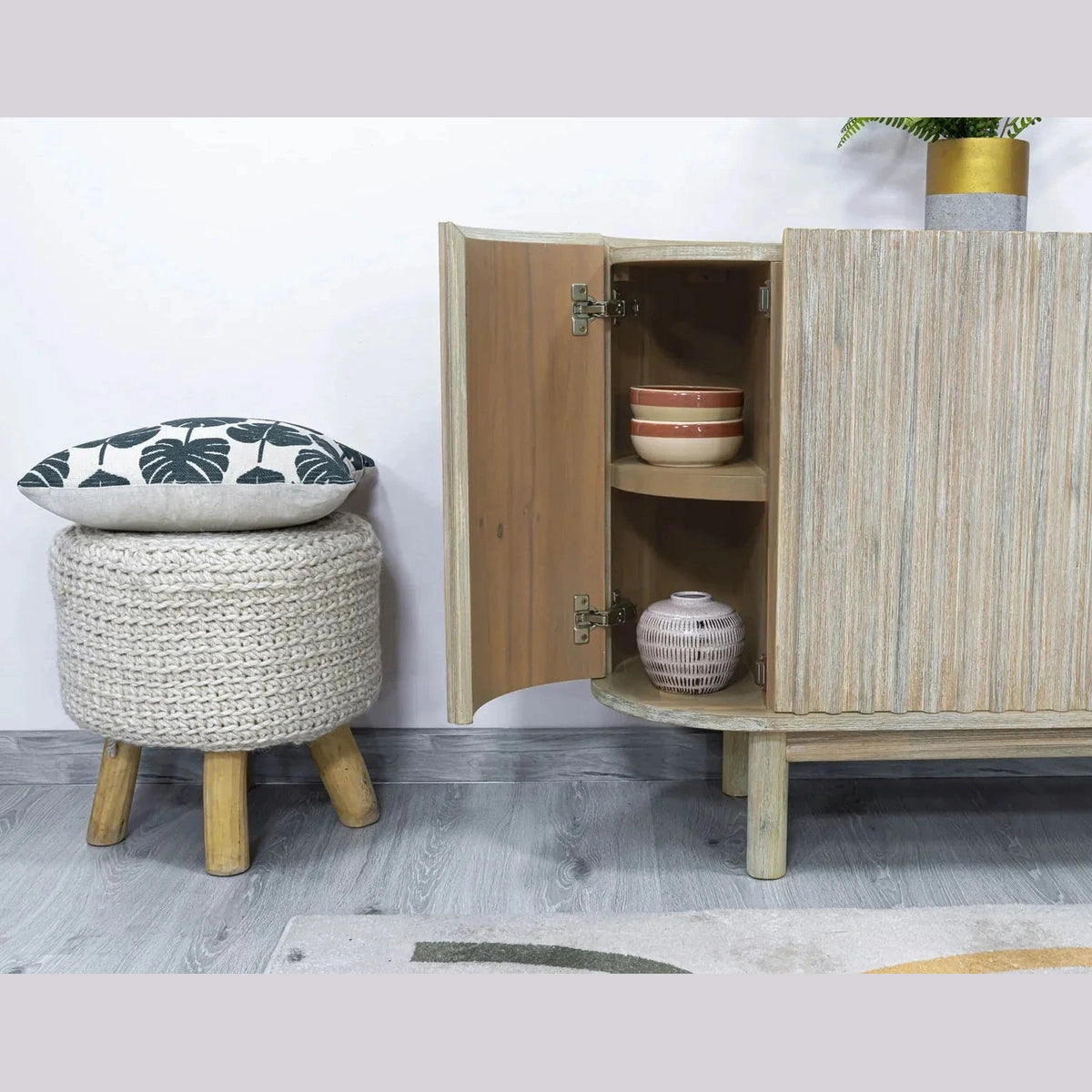Front perspective view of the Oasis 4-door sideboard featuring a light oak finish, rounded corners, and vertical matte black metal handles
