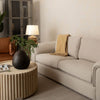 Side profile view emphasizing the slim low-profile silhouette of the Oasis glass and metal table