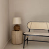 Perspective shot of the Oasis table in a minimalist corner setting highlighting its sculptural cylindrical form