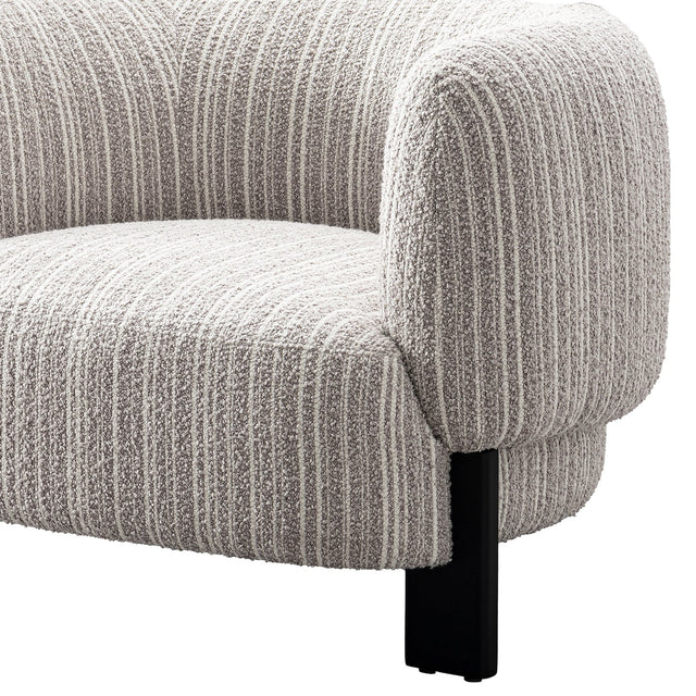 Side view of Odin upholstered accent chair with curved armrest