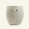 Front view of a minimalist barrel-shaped side table made from off-white fiber cement with a built-in horizontal handle cutout