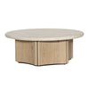 Three-quarter perspective highlighting the low profile and thick stone surface of the Oja round coffee table