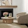 Wide shot showing the Oja coffee table paired with boucle accent chairs near a fireplace for a cozy modern look