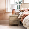 Close-up lifestyle shot featuring the Opera nightstand styled with a modern lamp next to a coordinating wood bed frame