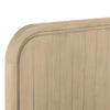 Close-up shot focusing on the soft rounded edges and subtle vertical paneling of the light oak headboard