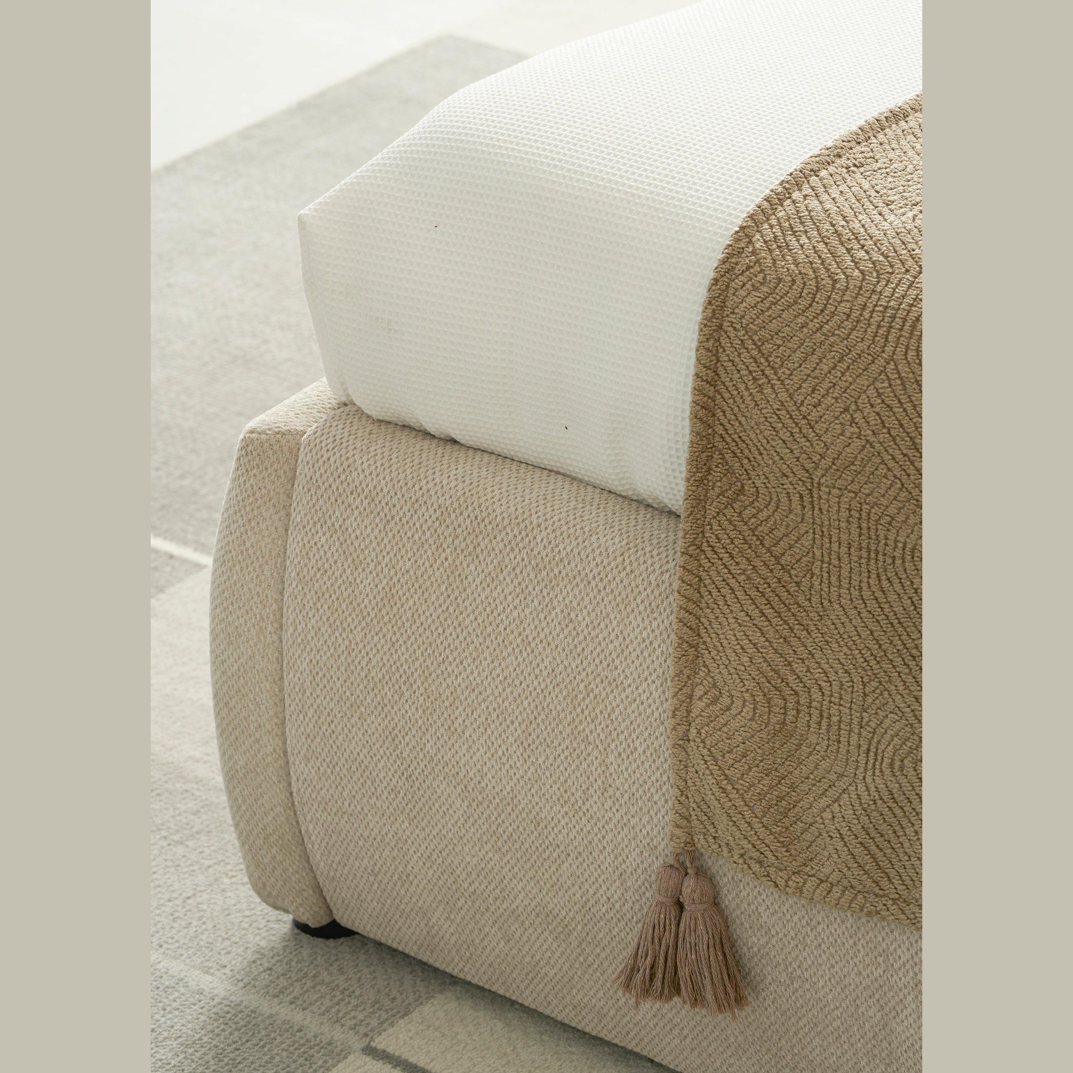Front view of the Aici storage bed featuring a cream fabric finish and a unique V-shaped geometric stitched headboard