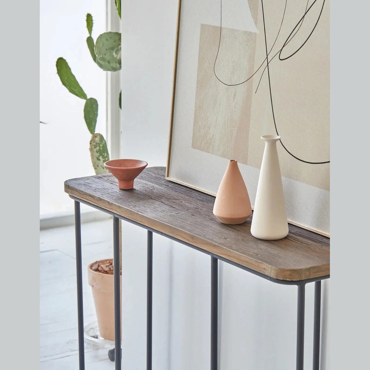 Lifestyle shot featuring the Preston console styled with minimalist ceramic vases and abstract wall art