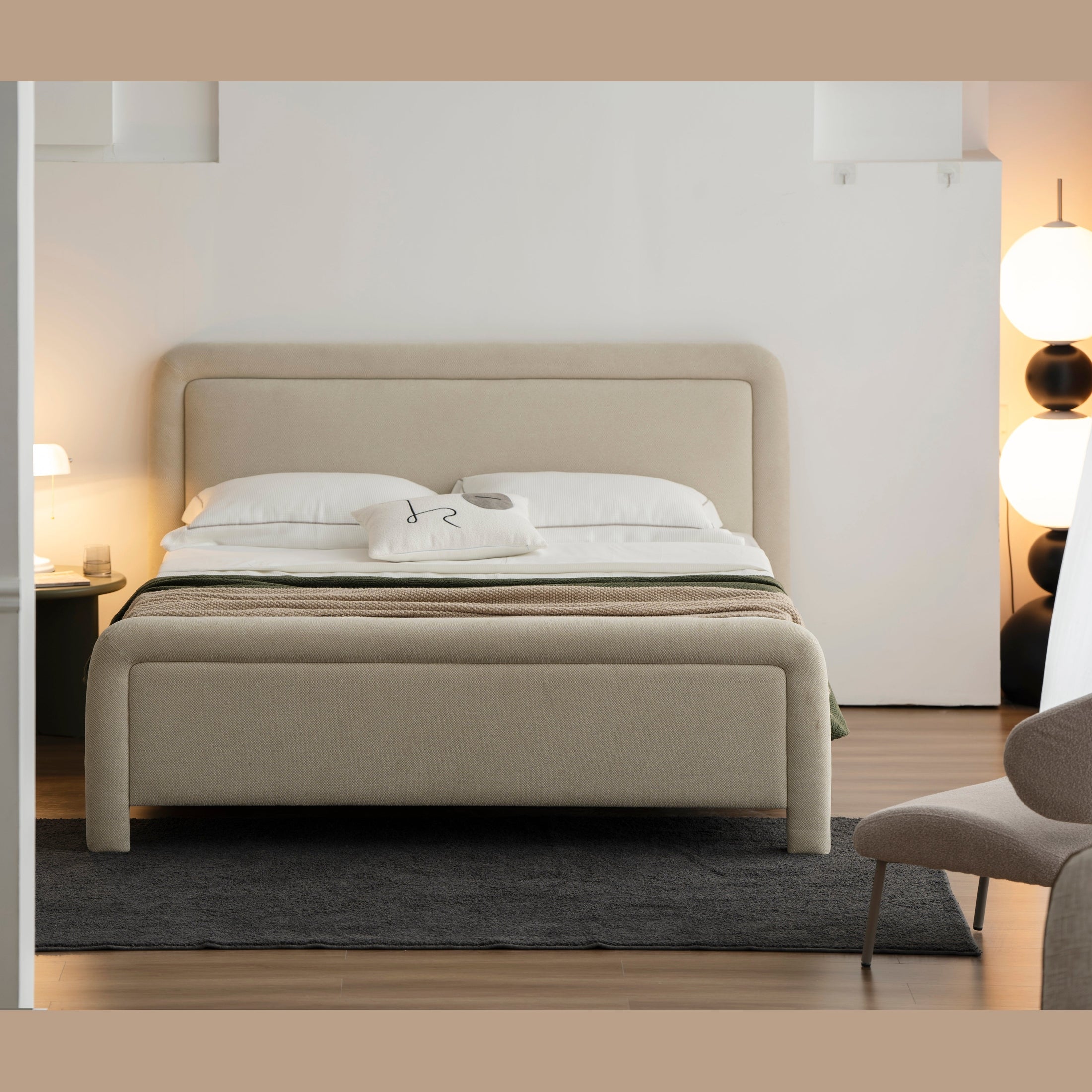 Lifestyle shot featuring the Alba bed styled with neutral linens and a dark wood nightstand in a bright contemporary room