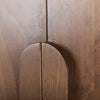 Macro shot focusing on the tactile rounded wooden door handles and the natural grain of the medium brown solid wood