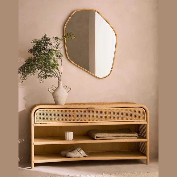 Perspective lifestyle view of the long Patagonia sideboard featuring a light oak frame with woven rattan panels and open lower shelving