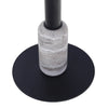 Detail shot focusing on the cylindrical travertine stone accent at the bottom of the black metal pedestal and the flat circular base