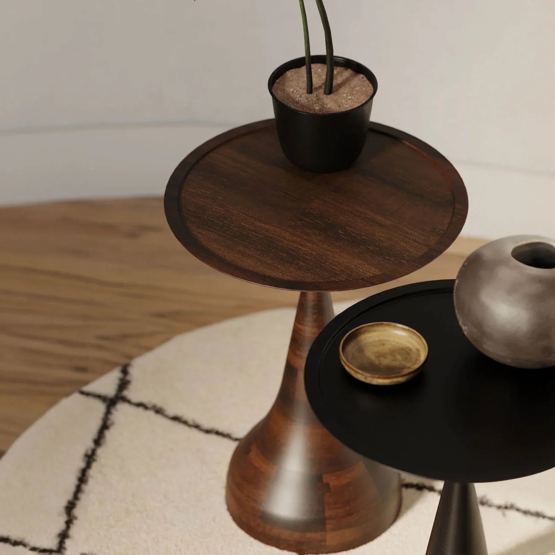 Three-quarter view of the Polina side table featuring a circular white marble top and a sculptural bronze-finished circular pedestal base