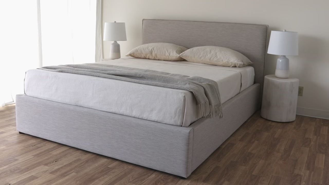 Lifestyle shot featuring the Julia bed in a bright bedroom styled with a white nightstand and minimal decor