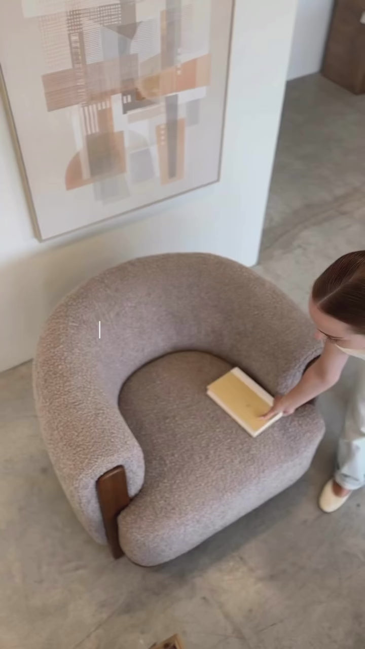 Three-quarter perspective highlighting the plush circular seat and curved backrest of the Keji chair