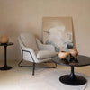 Close-up lifestyle shot of the Primo coffee table styled with decorative bowls in a minimalist living space with a grey accent chair