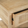 Close-up macro shot of the natural woven rattan caning and the slim rectangular brass drawer pull