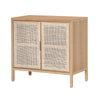 Three-quarter perspective view of a small natural oak sideboard featuring two doors with woven rattan panels and slim wooden legs