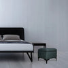 Lifestyle shot of the black Reece storage ottoman styled as a functional accent piece at the foot of a modern bed