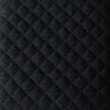 Macro detail shot showcasing the intricate diamond-tufting pattern and woven black fabric texture