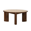 Front view of the Remix coffee table featuring a thick circular travertine top and three sculptural dark wood pedestal legs