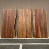 Comparative shot showing three natural wood slabs to highlight the unique grain and live edge variations of the Restore collection