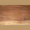 Perspective view from a low angle focusing on the sturdy black metal X-frame base and wood joinery