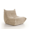 Three-quarter perspective of the beige Rigo chair highlighting its slouchy ergonomic shape.