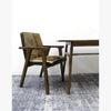 Side perspective of the Rio chair paired with a simple dark wood desk in a clean studio setting