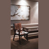 The Rio chair used as a statement piece in a minimalist hallway under a large abstract painting
