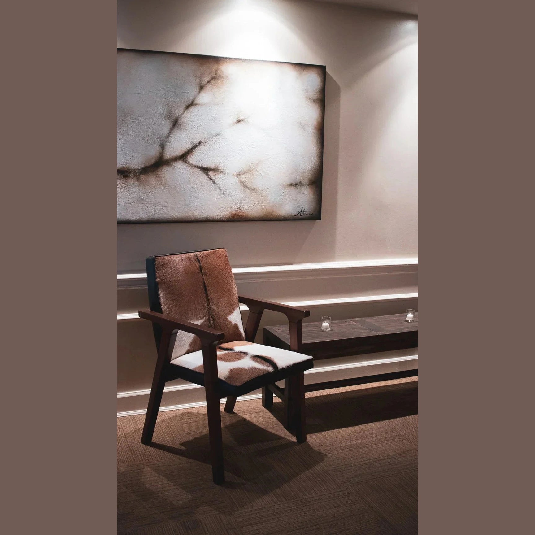 The Rio chair used as a statement piece in a minimalist hallway under a large abstract painting