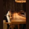 The Rio chair styled at a solid wood dining table in a moody contemporary dining room