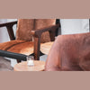 Close-up lifestyle shot of the armchair frame and natural upholstery in a warmly lit room