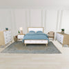 The Rosa chair styled in a bedroom setting at the foot of a bed with light wood furniture