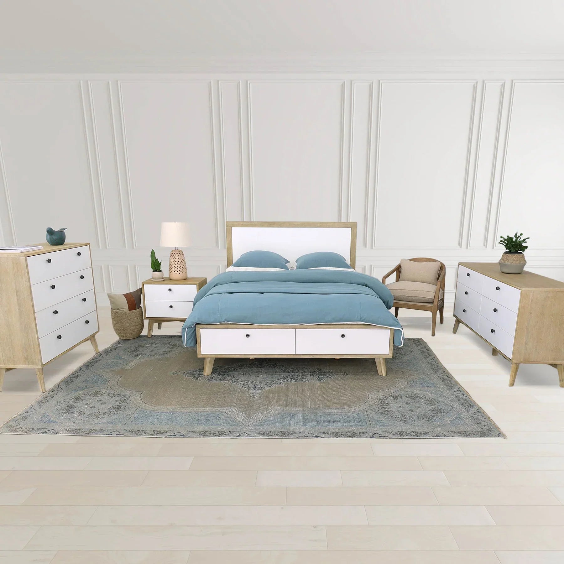 The Rosa chair styled in a bedroom setting at the foot of a bed with light wood furniture