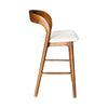 Side profile of the Rotondo walnut stool showing the elegant curve of the backrest