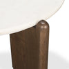 Macro shot focusing on the rounded top of the dark wood support leg and its seamless integration with the marble top