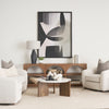 Wide lifestyle view showing the Rumer coffee table centered in a modern living room with a white sofa and abstract art