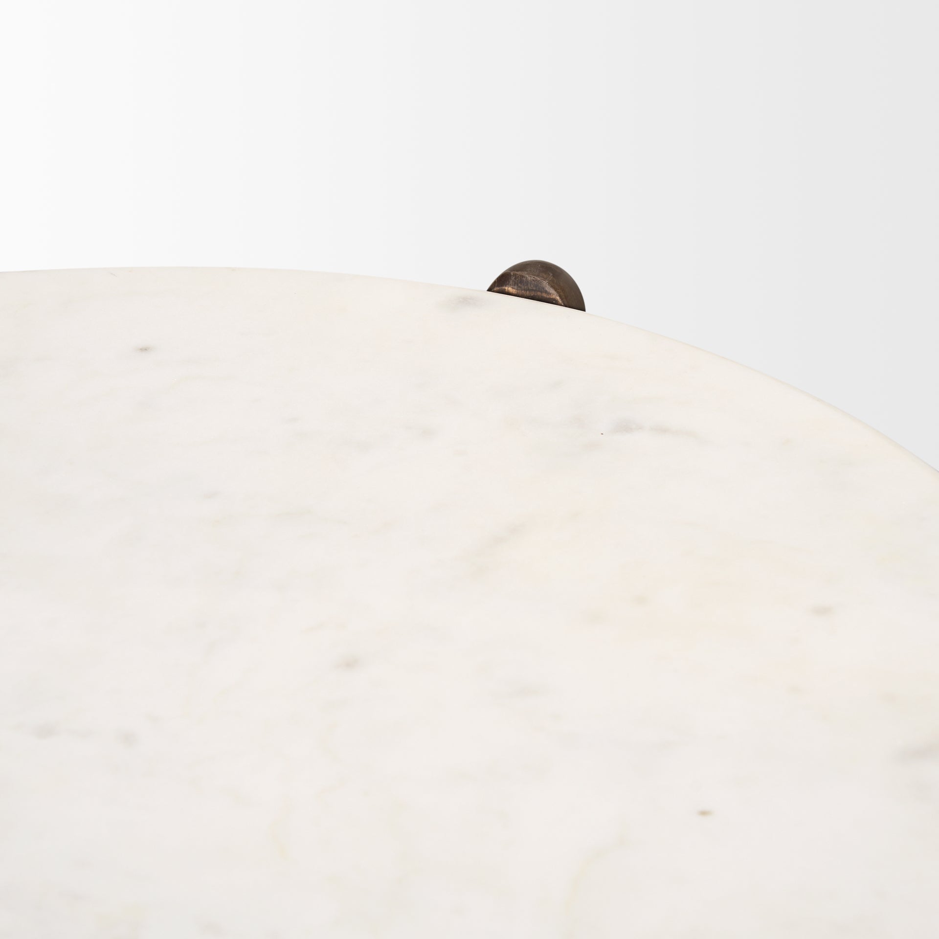 Close-up high-angle shot focusing on the soft grey natural veining and smooth polished finish of the white marble top