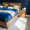 Angle lifestyle view of the styled Nevada bed highlighting the contrast between the wood finish and bright natural light